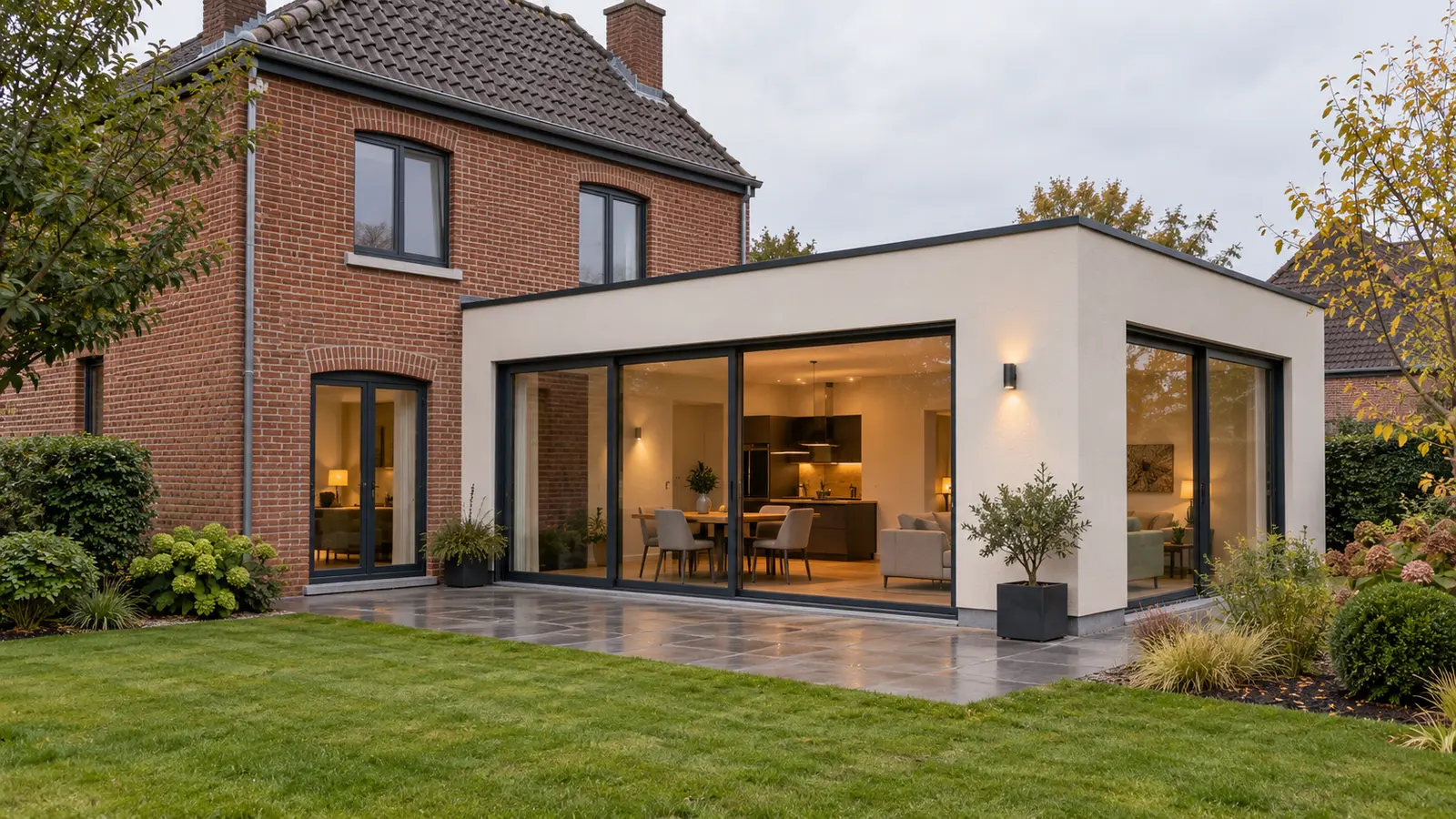 Maison belge en briques prolongée par une annexe contemporaine ivoire aux châssis anthracite